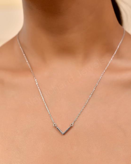 Silver necklace on a person's neck against a neutral background
