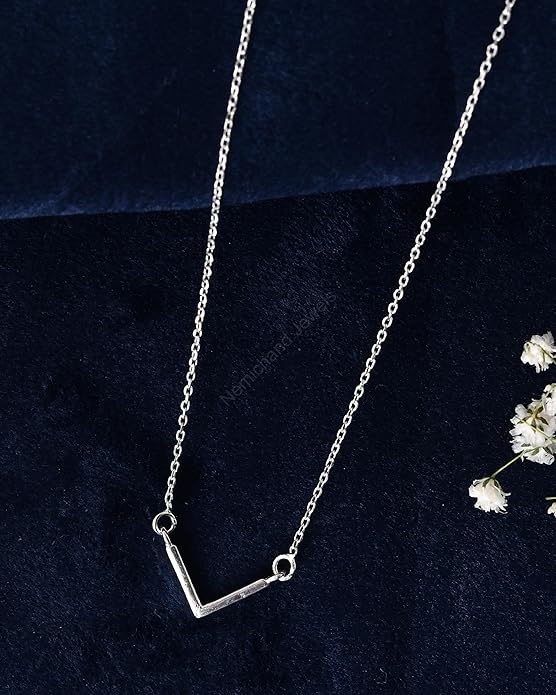 Silver necklace on a dark blue background with white flowers