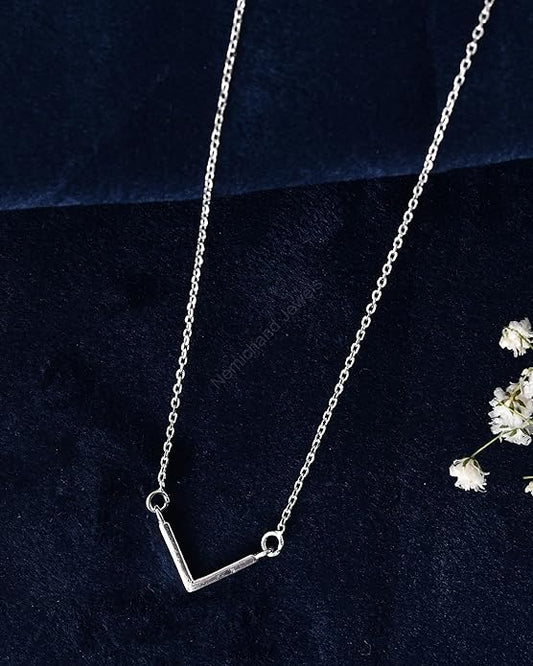 Silver necklace on a dark blue background with white flowers